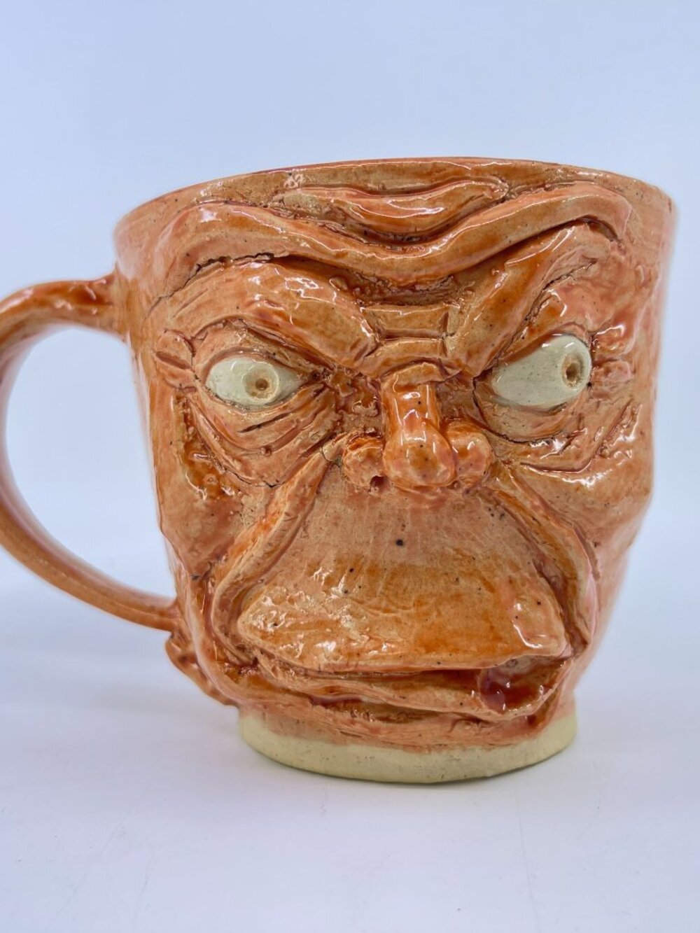 vintage handmade " ugly mug" with grotesque expression orange ceramic